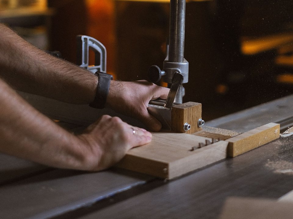 Mâini la fierăstrău, într-un atelier de tâmplărie